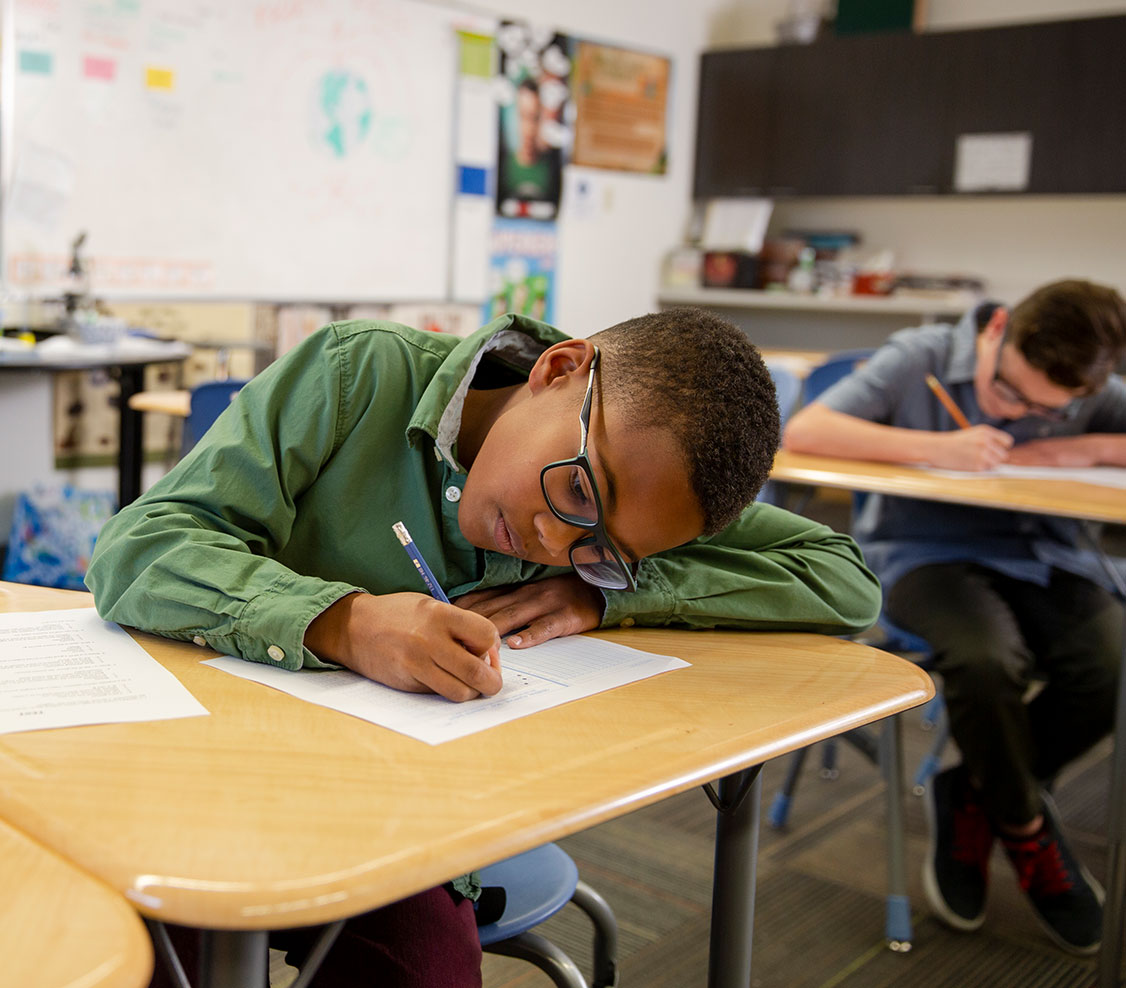 student concentrating at desk in classroom