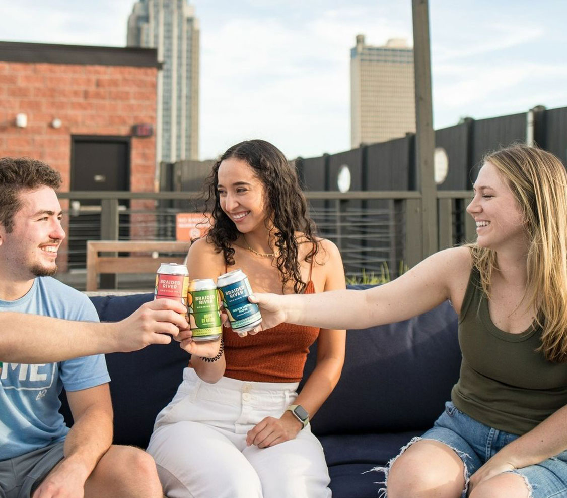 young people toasting beer on rooftop