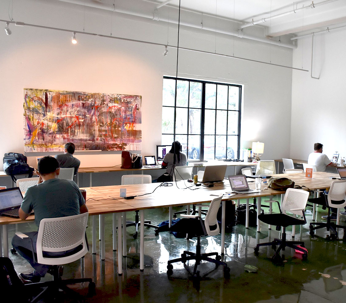 coworking space of long tables with people working on laptops