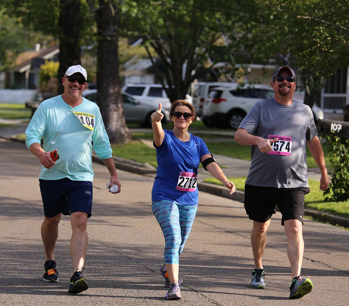 people participating in 5K with thumbs up smiling