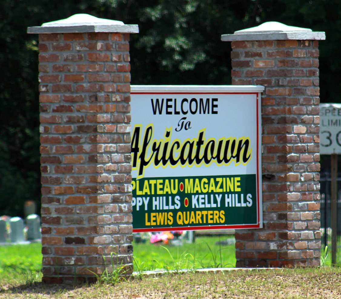 Welcome to Africatown sign with brick columns